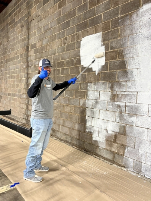 Day of Caring Volunteer Painting Wall